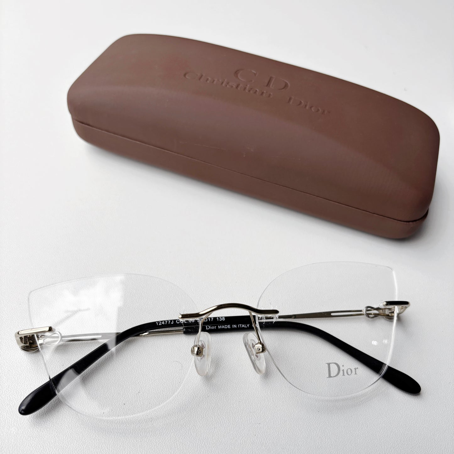 Dior eyeglasses with a brown case on a white background